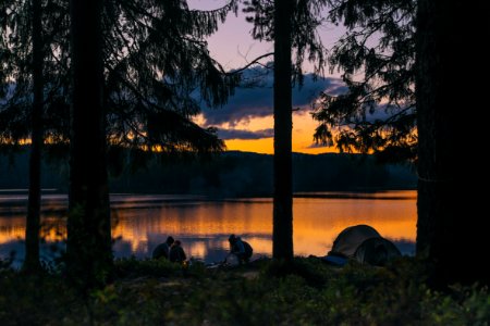 people beside body of water at golden hour photo