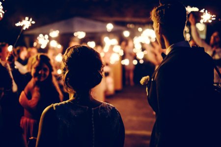 man standing near the woman walking in party during nighttime photo