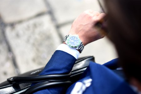 person looking at silver-colored analog watch