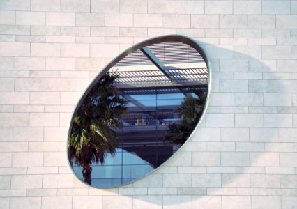 oval mirror on white brick pathway photo