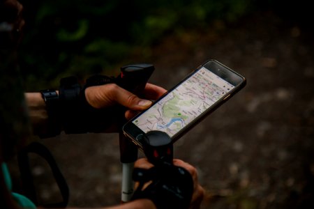 person using smartphone with nordic walking sticks photo