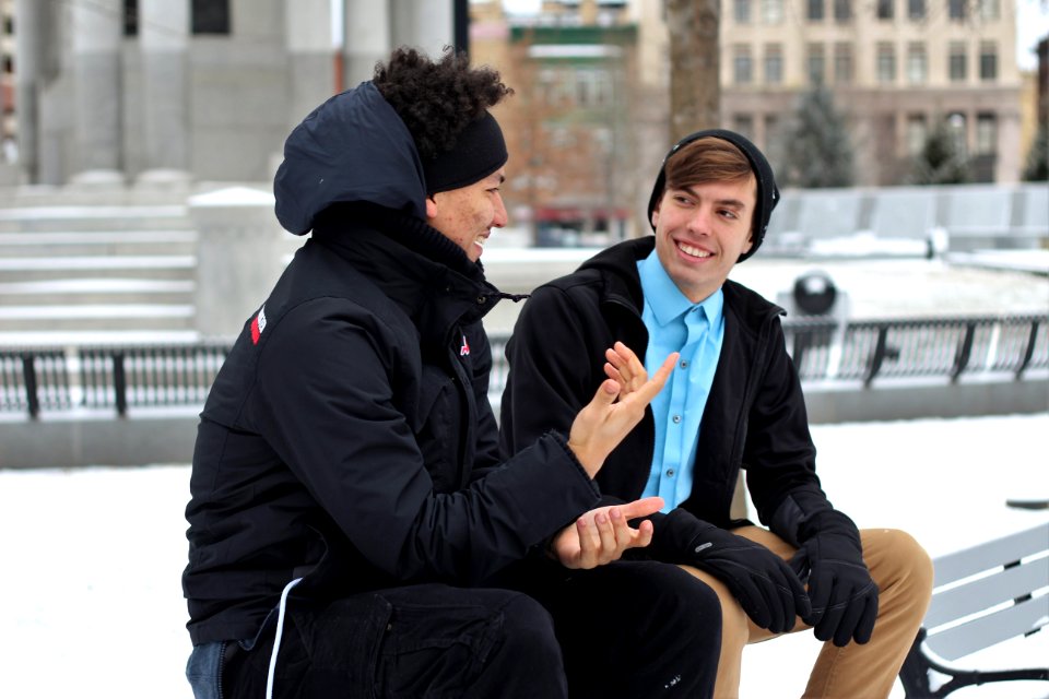 two men talking while sitting on bench photo