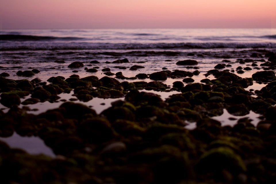 rocks on seashore along ocean wave