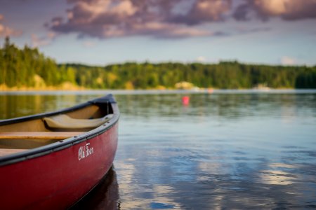 red canoe boat on body of water photo