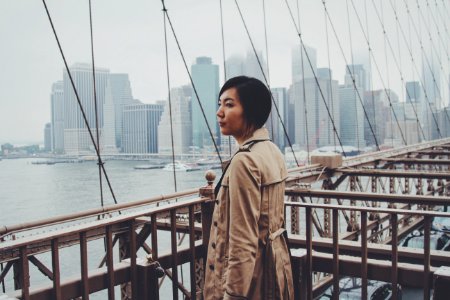woman standing on bridge railings at daytime photo
