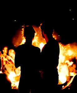 two persons standing in front of bonfire photo