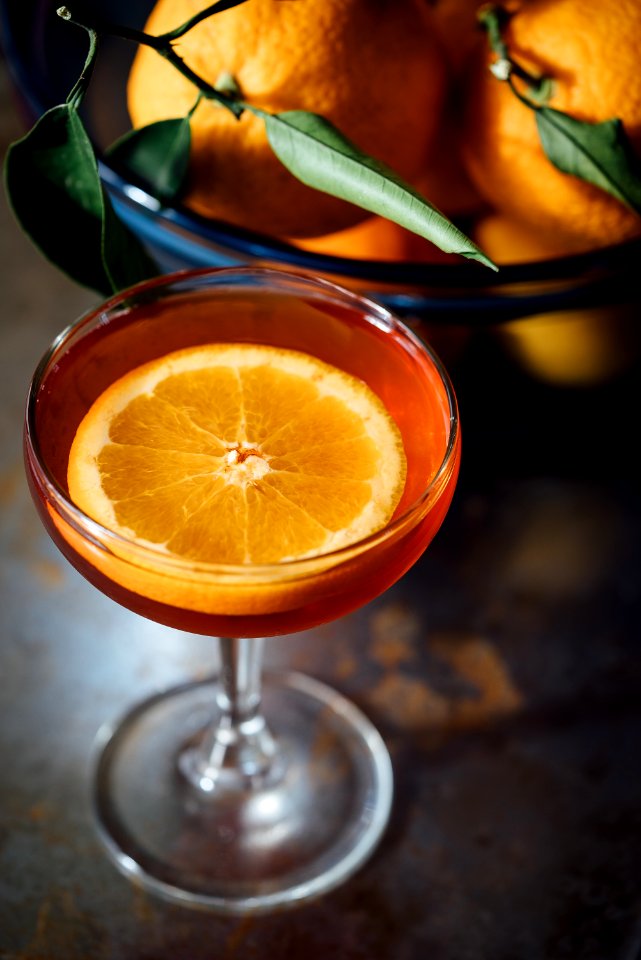 orange slice in a wine glass full of orange liquid
