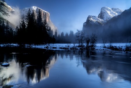 reflection of mountains and trees on body of during snow photo