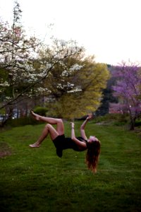 woman back flipping in the garden