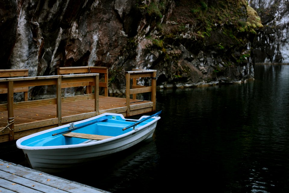 white and blue boat on dock