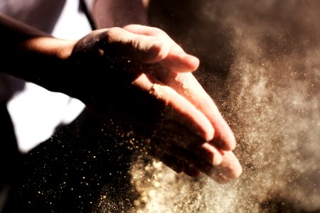 person clapping its hand with sand