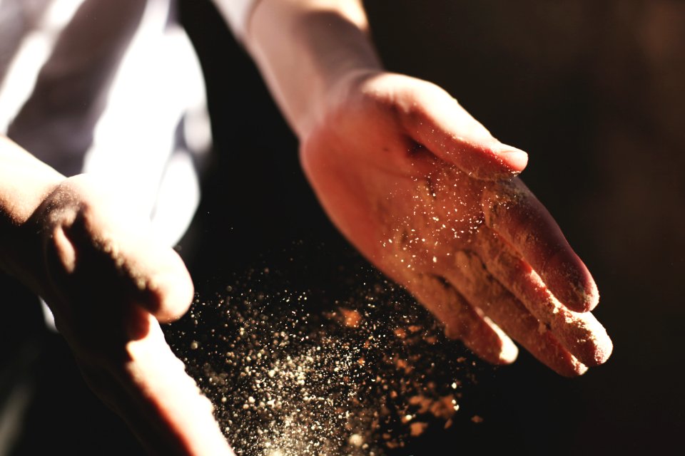 person's hand with dust during daytime