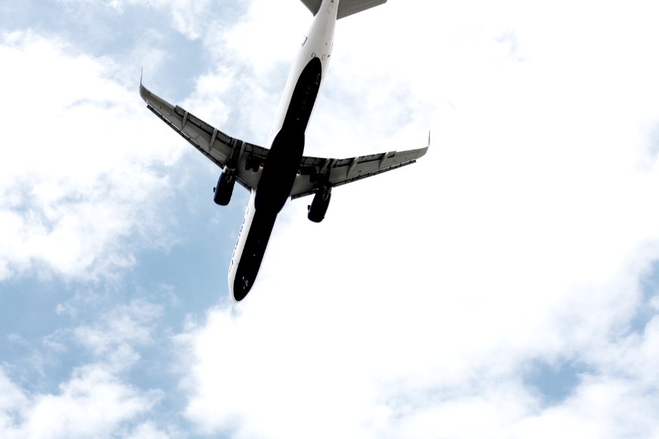 white air plane under the clouds