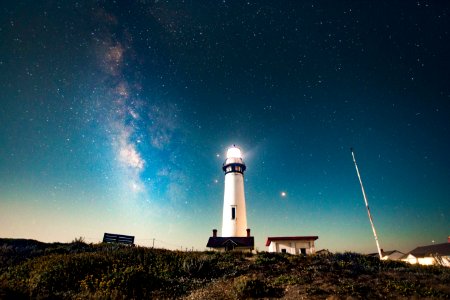 photo of turned on white lighthouse photo