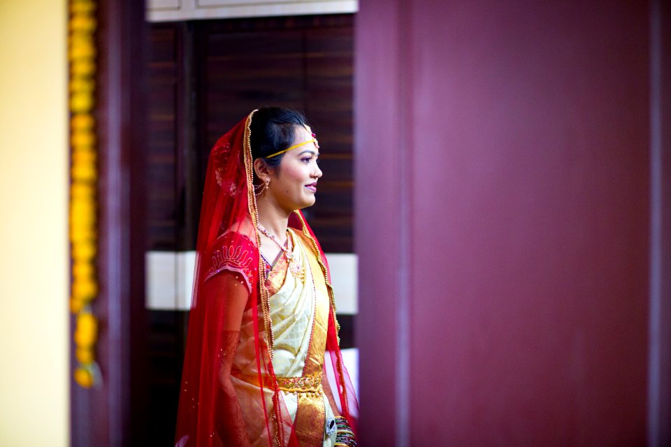 woman in sari dress standing near purple wall