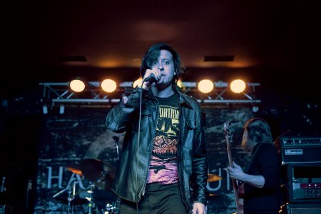 man in black leather jacket singing with microphone photo