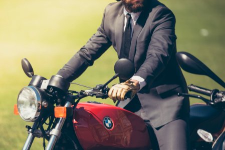 person wearing gray suit jacket riding BMW motorcycle