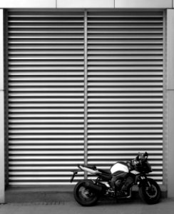 backbone motorcycle parked beside roll-up door photo