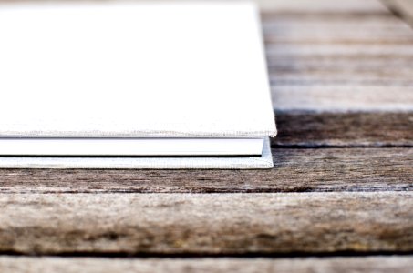 White hardcover book sitting on the wooden table photo