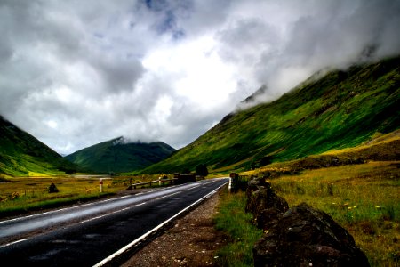 narrow road near grass and mountain