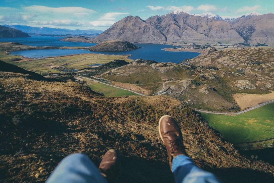 person sitting on cliff during daytime