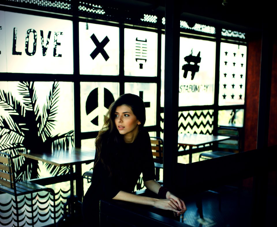 woman in black quarter-sleeved top leaning on black desk