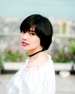 selective focus photo of woman wearing white top and black choker necklace