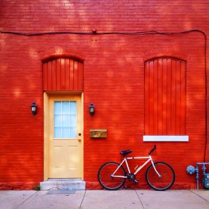white bicycle parked beside wall photo