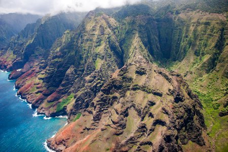 green and brown mountain near body of water in aerial photography photo