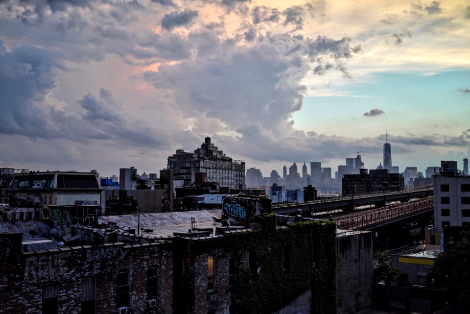 photo of black concrete building under white clouds at noontime