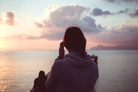 woman in gray hoodie standing at dock photo