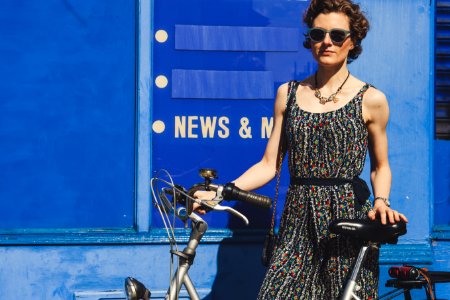 woman holding gray bicycle