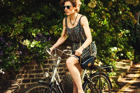 woman riding bicycle on road near green plants at daytime photo