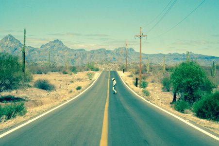 man standing in the middle of road photo