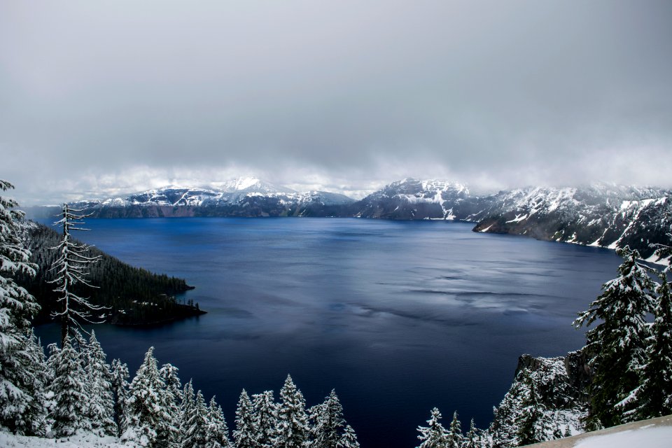 body of water surrounded by mountain covered with fog landscape photo
