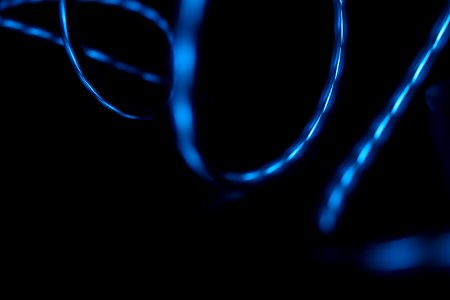 Blue light reflected in the surface of glossy swirling wires photo
