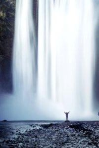 person standing beside waterfall photo