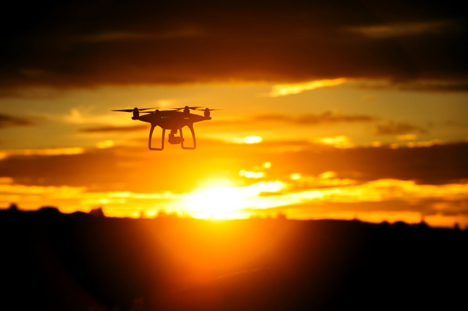 silhouette camera drone flying midair