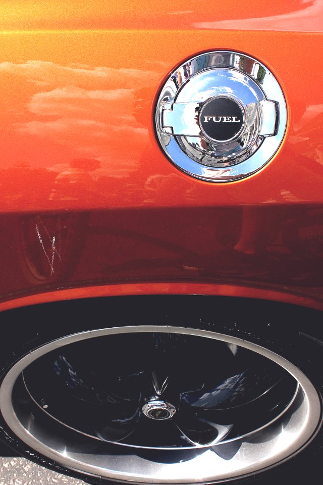 The fuel tank cap on an orange car.