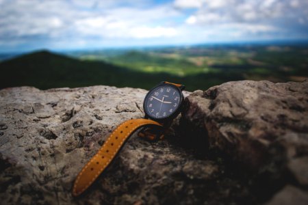 round black analog watch on stone photo