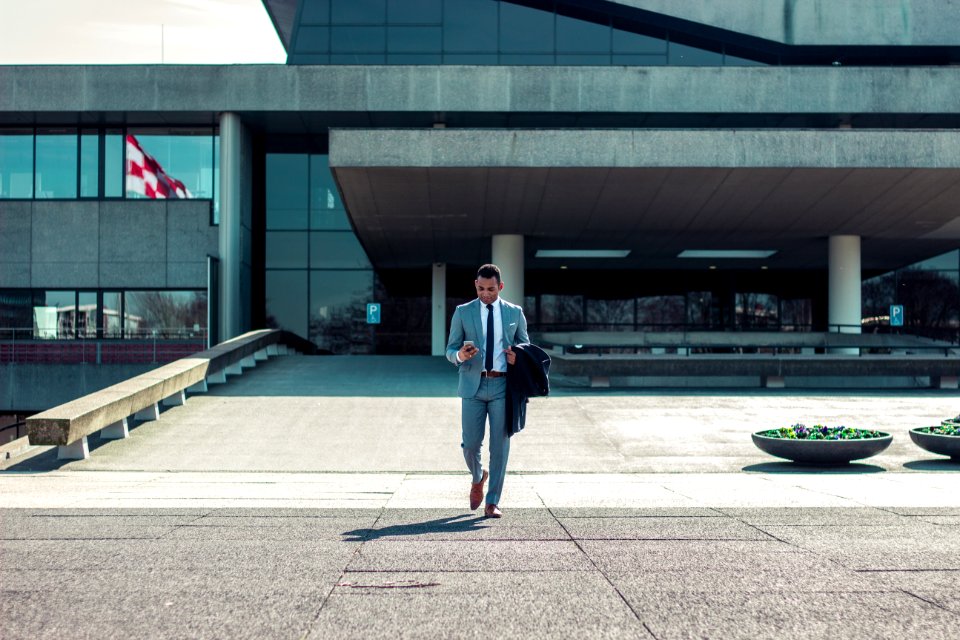 man walking while holding black coat