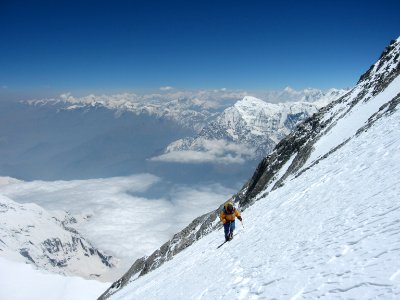 person climbing snow-covered mountain during daytime photo