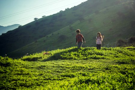 2 women walking on green grass field during daytime photo