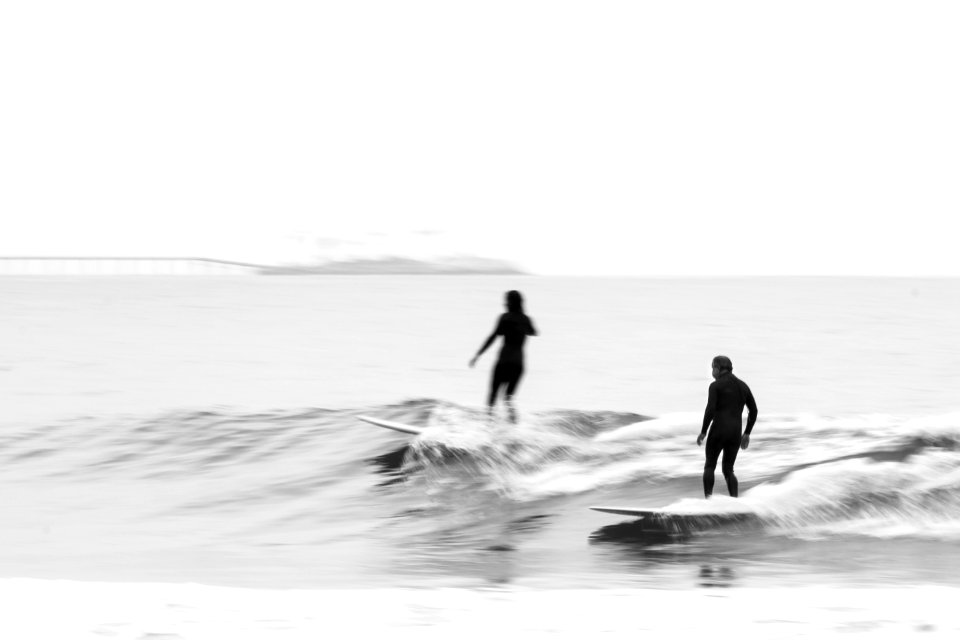 grayscale photography of two person surfing