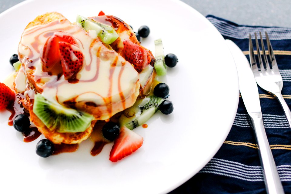 plate of pancake with strawberry and kiwi toppings