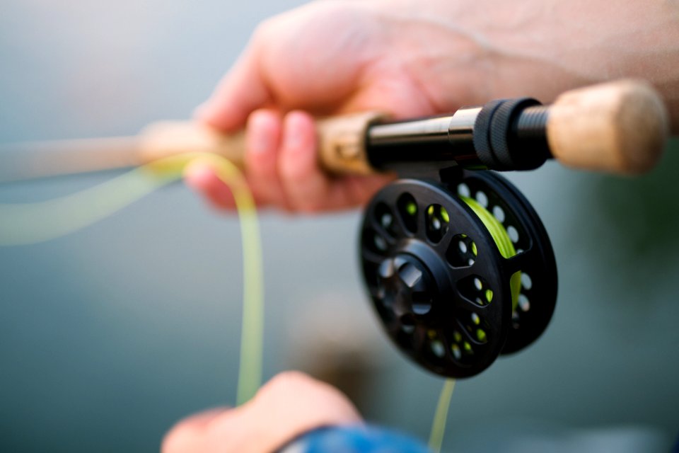 person holding black and brown fishing rod