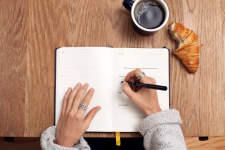 person writing on a book photo