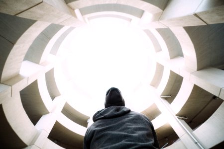 photography of person wearing gray hooded jacket inside building during daytime photo