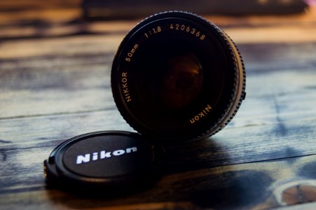 black Nikon zoom lens on brown wooden surface photo