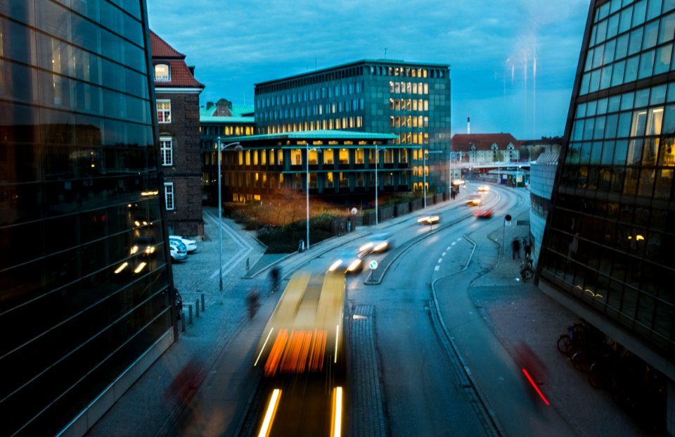timelapse photography of vehicle near curtain buildings